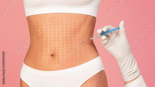 Beautician doctor making injection at belly area of young woman in underwear