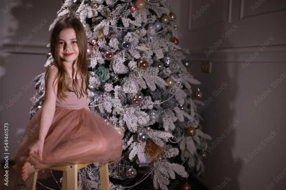 Child in smart clothes in front of the Christmas tree. Waiting for the new year. Child in smart clothes in front of the Christmas tree. Waiting for the new year.