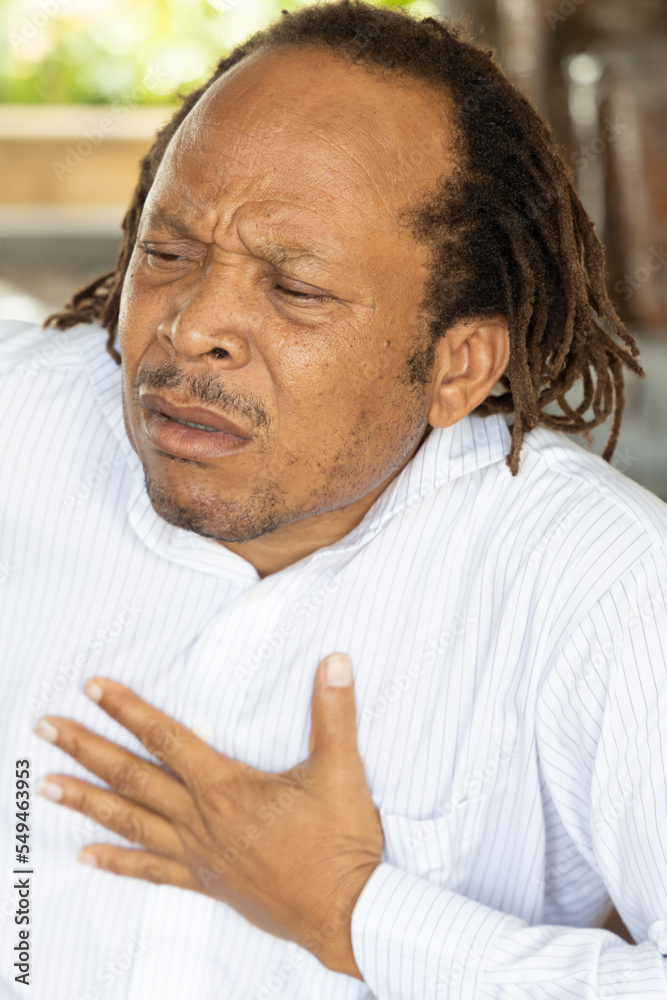 Fototapeta premium Sick middle age African black man with heart attack or chest pain