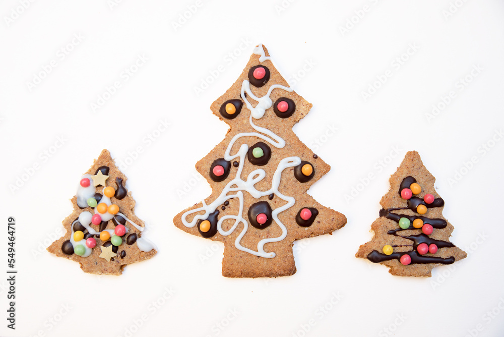 three christmas tree cookies at white background with copy space