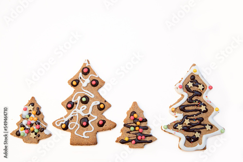 four christmas tree cookies at white background with copy space