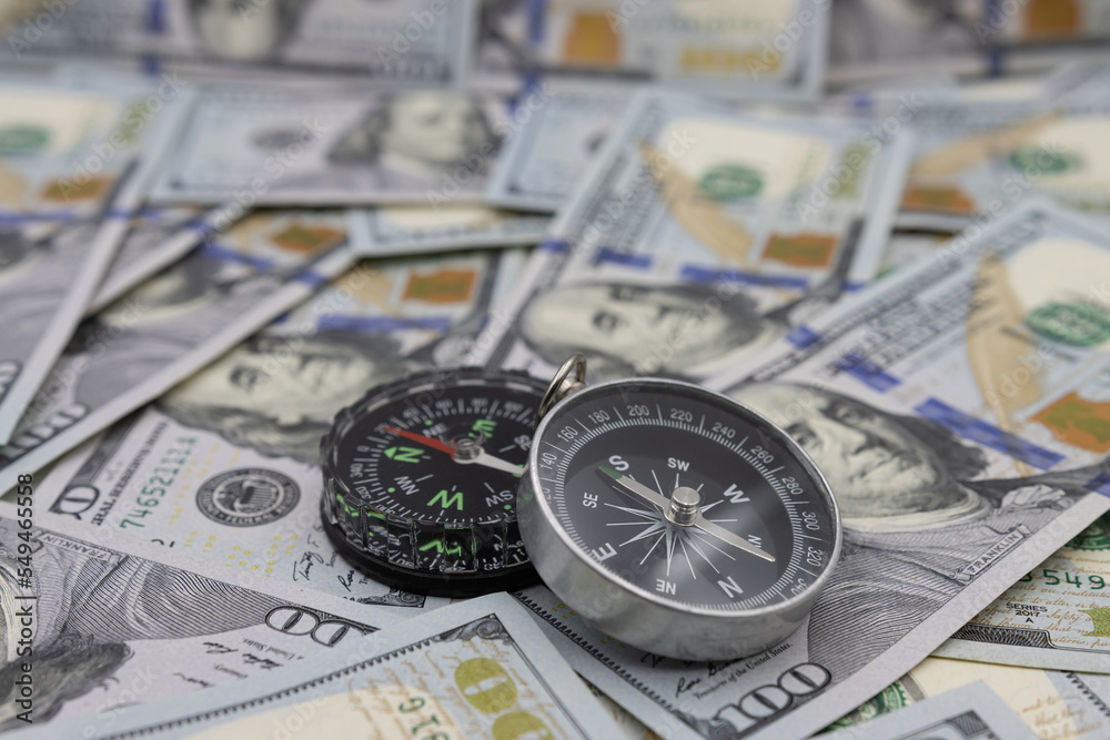 Two navigational compasses against the background of American dollars. Business path concept Two navigational compasses against the background of American dollars. Business path concept