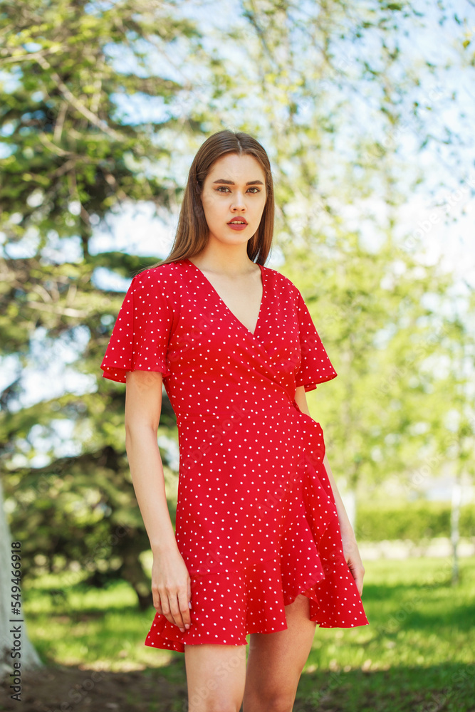 Fototapeta premium Young beautiful brunette girl in summer dress