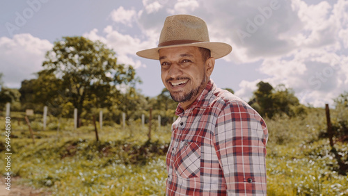Portrait of young farmer man in the casual shirt and hat in the farm
