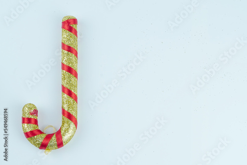 Gold and red candy canes with glitter on white background