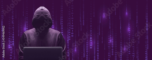 Silhouette décalée sur la gauche du cybercriminel devant son écran d'ordinateur portable sur fond de données binaires pourpre