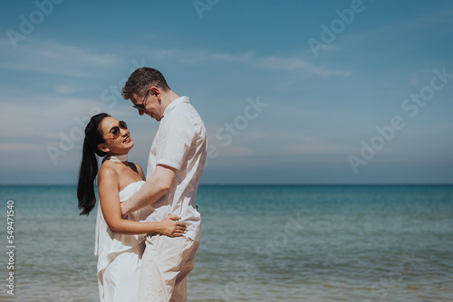 Romantic couple love happy and hugging on the beach. Young man and woman smiling and enjoying together on summer vacation. honeymoon lifestyle, Happy aniversary. © sarayutsridee