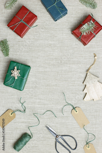 Christmas and New Year gift boxes, zero waste, eco friendly packaged gifts in kraft colored paper, green fir tree branches on table, preparation colorful xmas presents, eco christmas concept
