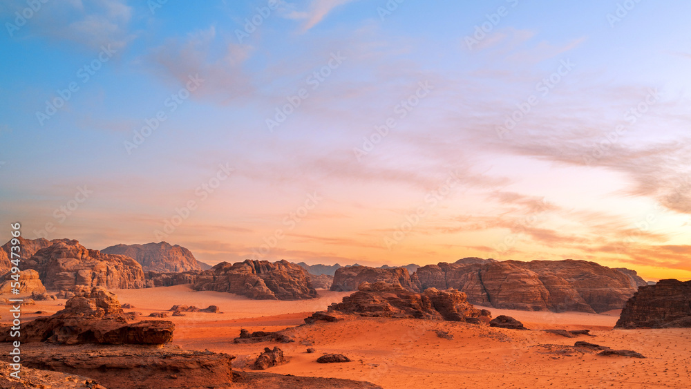 Wadi Rum, Jordan. A beautiful vibrant blue and orange sunset, Arabian desert, a dystopian martian landscape with unique rock formations and dunes. Backdrop for graphic resource or copy space no people - obrazy, fototapety, plakaty 