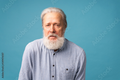 Obraz na płótnie Portrait of unhappy grumpy pissed off senior mature man on blue background