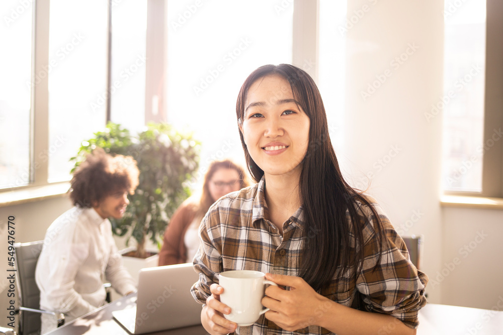 Japanese girl in the foreground, taking a break in the office, during work . Japanese girl in the foreground, taking a break in the office, during work .