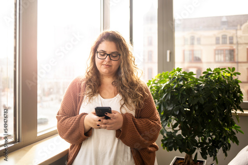 Portrait of a woman, using phone in the office