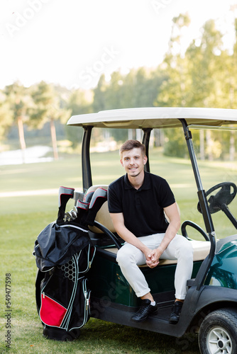 Young man in golf car outdoors. High quality photo