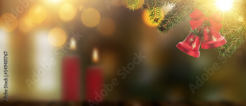 Weihnachtsbaum im Vordergrund vor einem unscharfen Wohnzimmer mit Kerzen