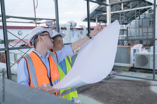 Two young engineers working together,Discuss the construction of a warehouse,See the construction drawings for the storage facility.