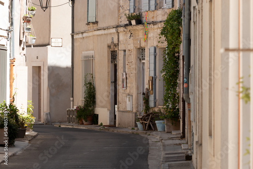 A typical  narrow street in the Provence region of France. A street with building facades in the city of Arles. A day in summer.