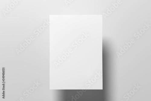 A sheet of paper mock up floating above the white table. © dimamoroz