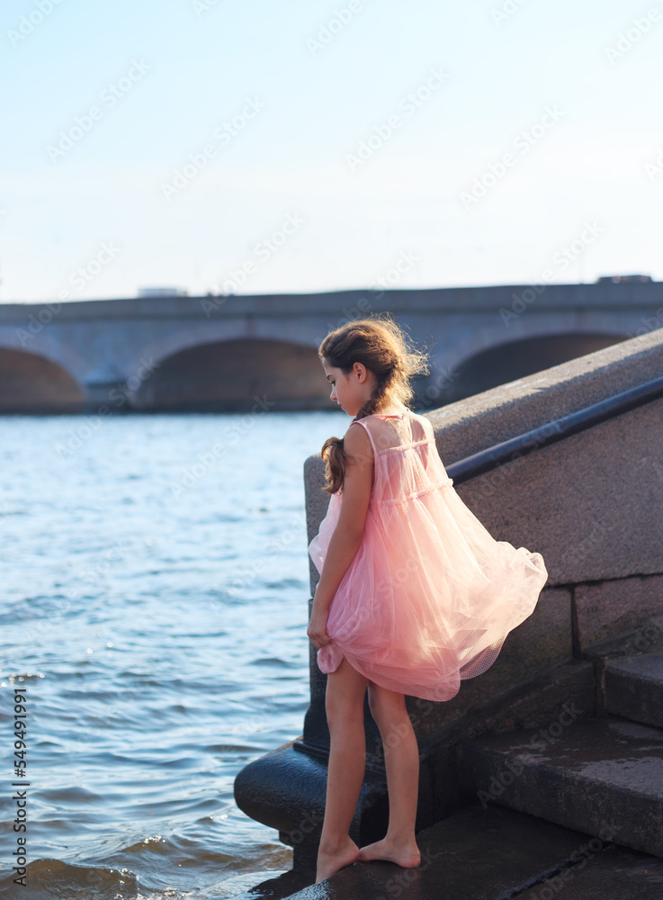 Beautiful Little Girl is playing with waves at sunset.  Summer Sunny Day,  happy Kids concept
