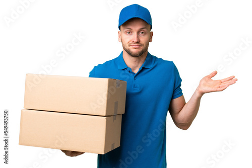 Delivery caucasian man over isolated background having doubts while raising hands © luismolinero