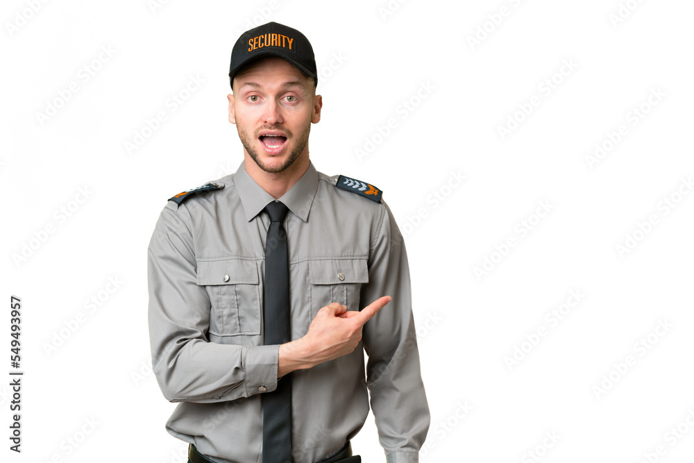 Young security caucasian man over isolated background surprised and pointing side Young security caucasian man over isolated background surprised and pointing side