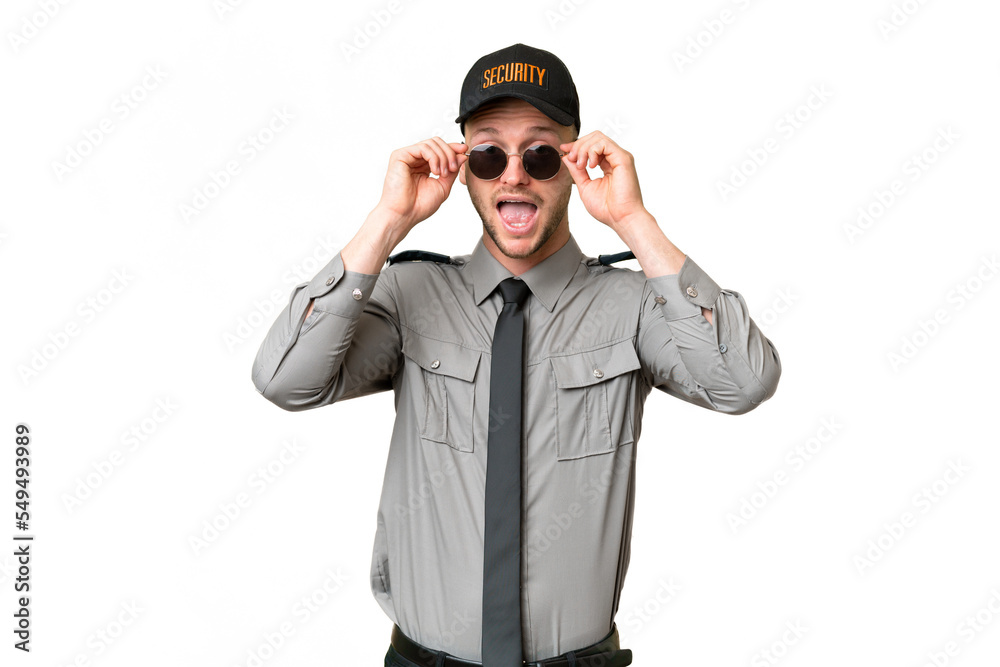 Young security caucasian man over isolated background with glasses and surprised Young security caucasian man over isolated background with glasses and surprised