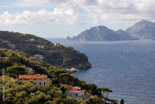 Fototapeta Naklejka Na Ścianę i Meble -  Residential Homes on Mountain by the Sea with Capri Island in background. Near Touristic Town of Sorrento, Italy.