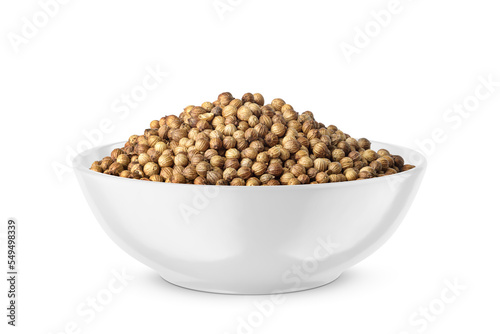 Dry coriander seeds in round bowl isolated on white. Side view.