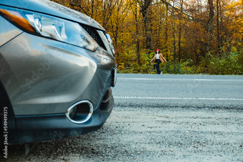Wallpaper Mural a woman walks along an autumn road, the headlights of a parked car closeup Torontodigital.ca