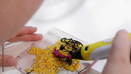 Close-up of 3D pens in the hands of a child. The child draws with a 3D pen.