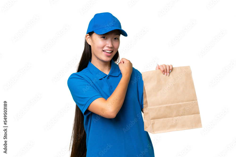 Young Asian woman taking a bag of takeaway food over isolated background celebrating a victory Young Asian woman taking a bag of takeaway food over isolated background celebrating a victory