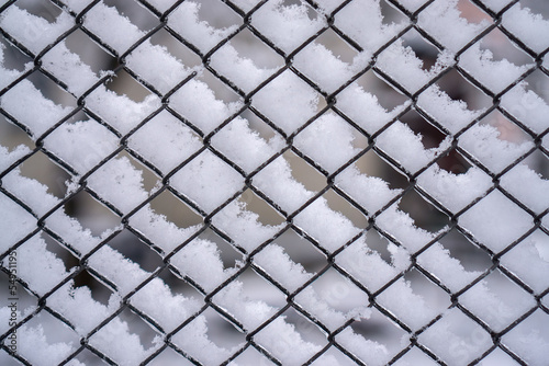 Iron mesh netting in the snow. Abstract winter pattern for the background.