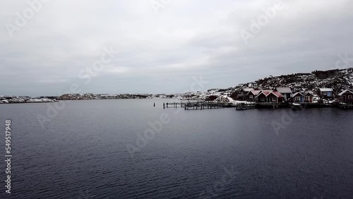 Aerial view of the snowy shore of a lake with cozy rural wooden houses photo