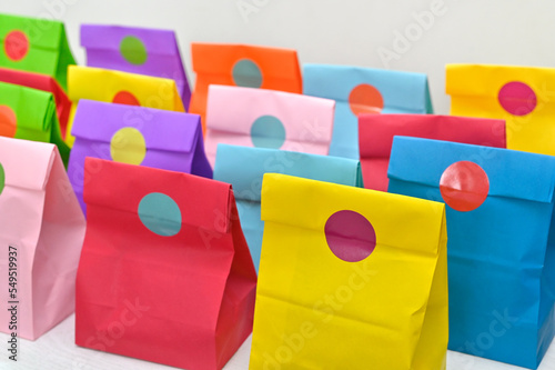 Set of colorful shopping folded paper bags on white background. Paper shopping bags mockup, blank rectangular gift packs. Mock up for branding and corporate identity design.