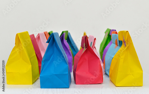 Set of colorful shopping folded paper bags on white background. Paper shopping bags mockup, blank rectangular gift packs. Mock up for branding and corporate identity design.