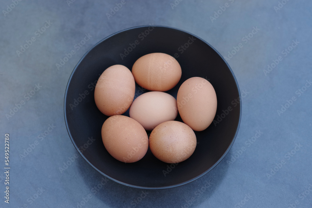 Six brown eggs in a black bowl Six brown eggs in a black bowl