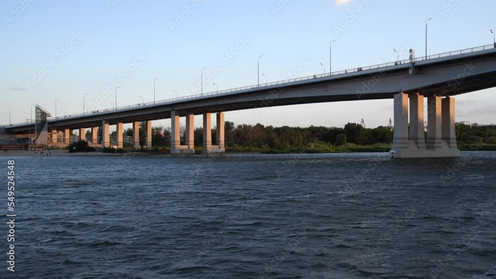 Side view of bridge building standing on Don river from sailing boat at sunset. Clear blue sky. Real time video. Transportation theme. Side view of bridge building standing on Don river from sailing boat at sunset. Clear blue sky. Real time video. Transportation theme.