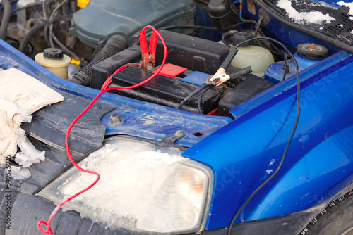 Connecting high voltage wires to the car battery. Charging automobile discharged battery