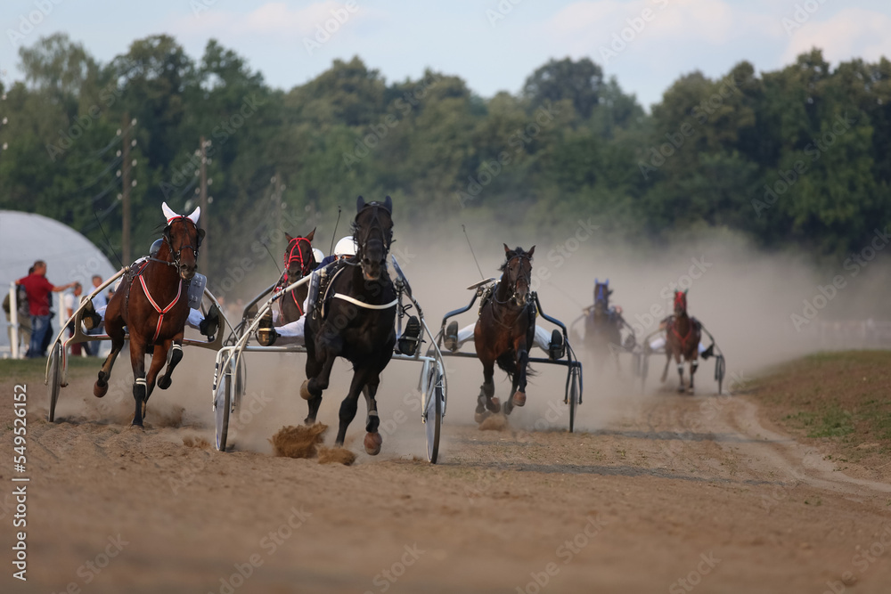Horses and riders running at horse races Horses and riders running at horse races