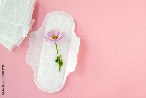 Fototapeta Naklejka Na Ścianę i Meble -  Sanitary pads and white flowers on pink background. Concept of critical days, menstruation	