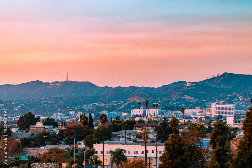 Los Angeles, California landscape with the hollywood sign and griffith observatory in the background during sunset.