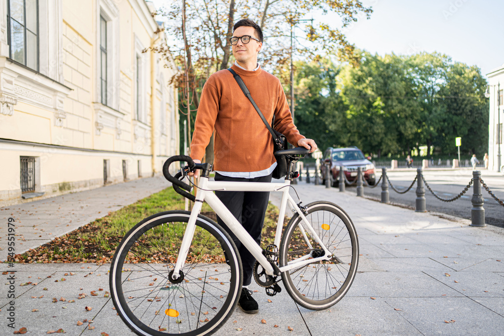 A young man on a business bicycle goes to work urban eco transport
