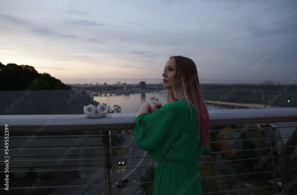 Rear view shot of a beautiful female tourist enjoying sunset view of a river in the city Rear view shot of a beautiful female tourist enjoying sunset view of a river in the city