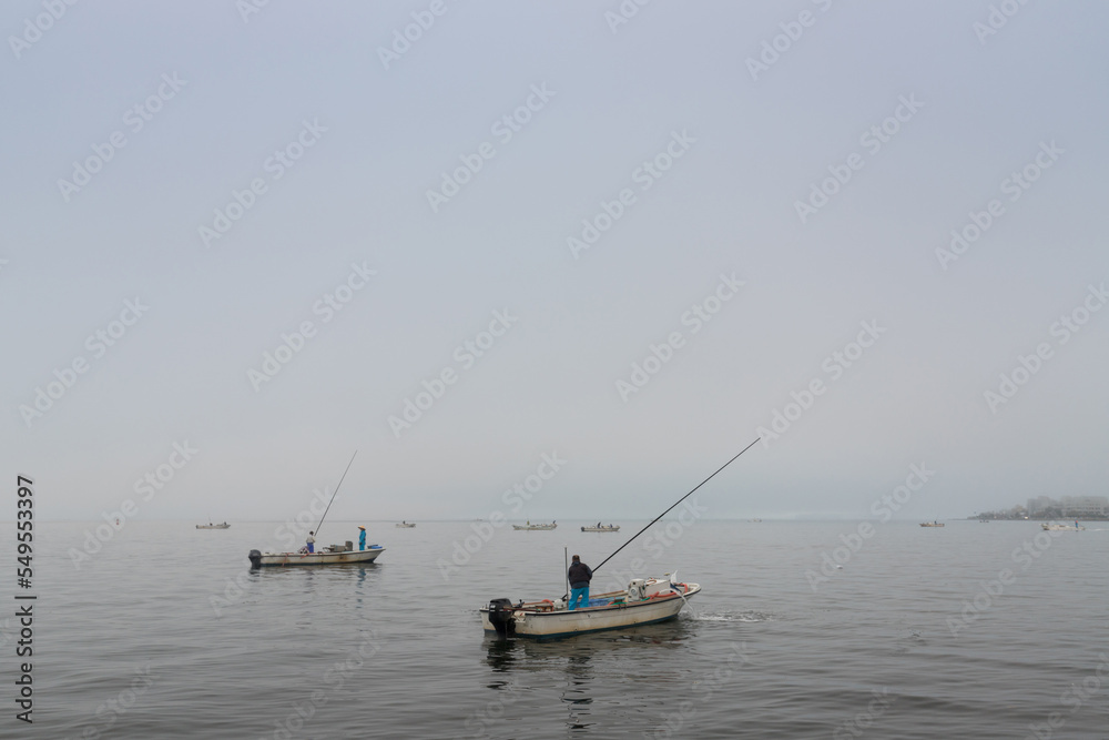 秋の朝の宍道湖のシジミ取り作業している漁船の様子