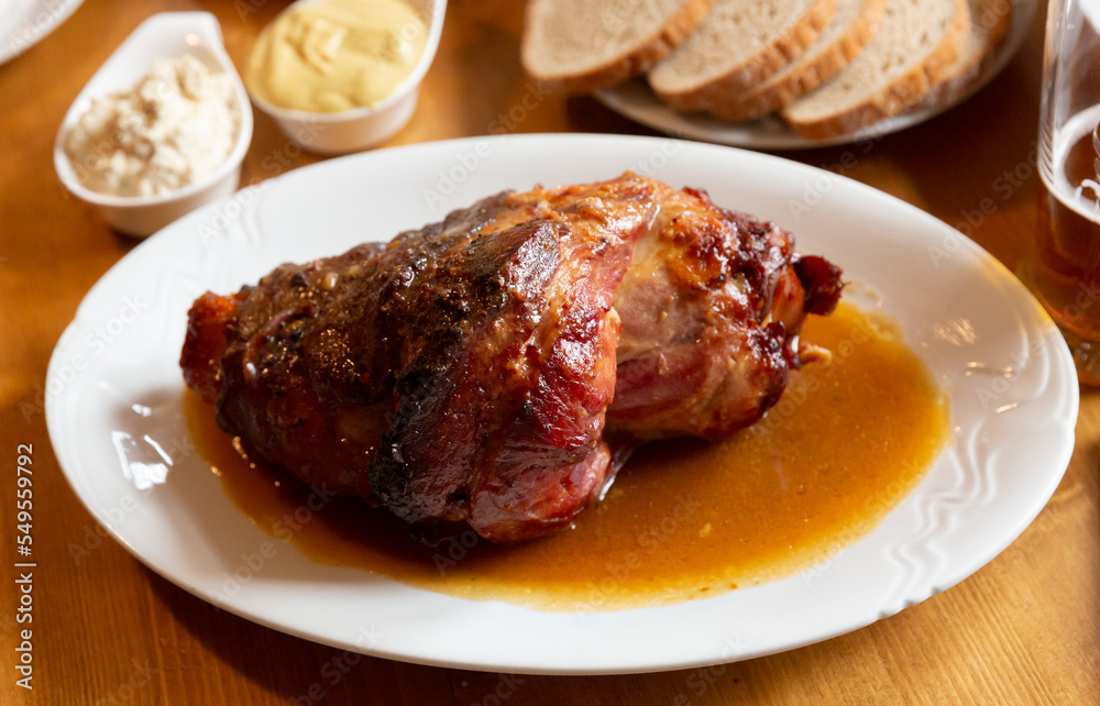 Appetizing pork knuckle baked in oven with mustard, spicy horseradish and bread. Typical czech dish