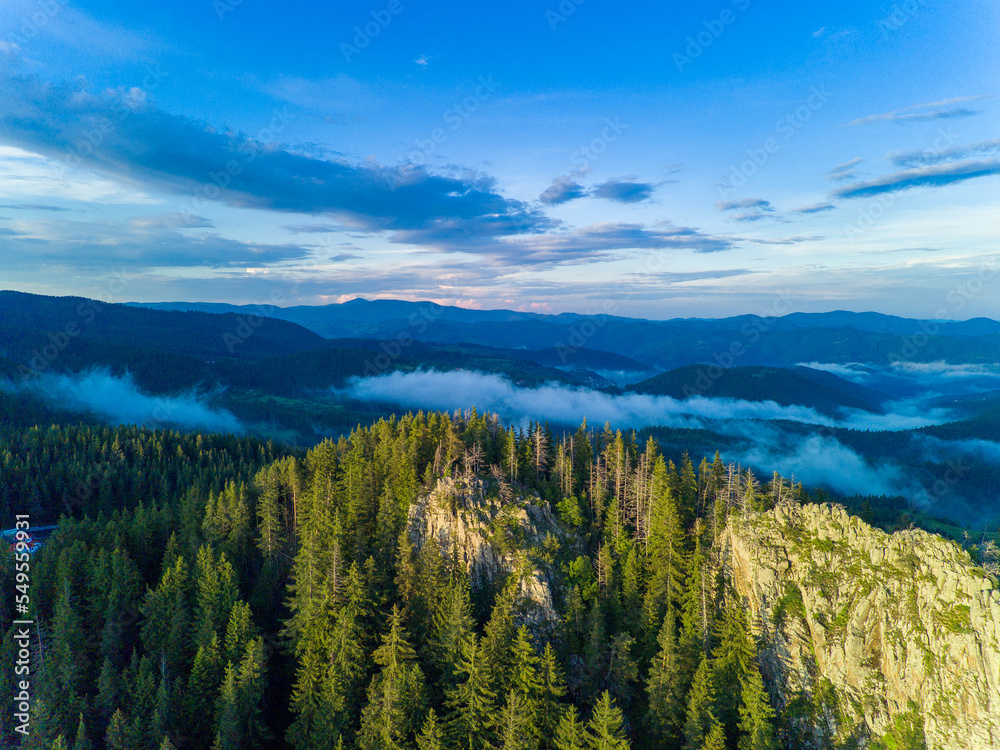 Peak of mountain range with forest in valley Rhodope mountains under sunset