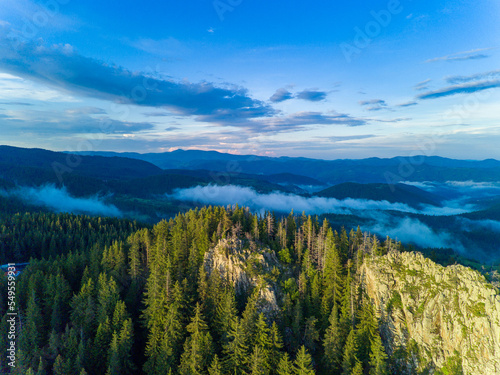 Peak of mountain range with forest in valley Rhodope mountains under sunset