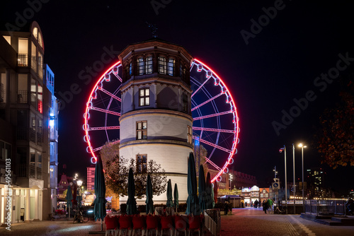 Night scenery of Weihnachtsmarkt, Christmas Market and ferris wheel at Burgplatz square in Düsseldorf, Germany.