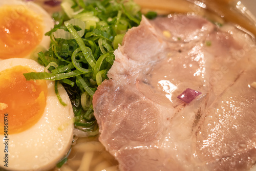Close up view at chop leek, sliced pork Chash, and boiled egg on the top of Japanese ramen noodle soup. 