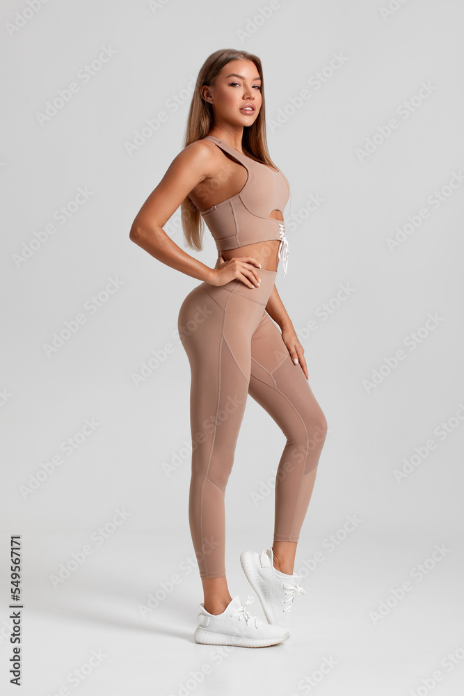 Fototapeta premium Fitness woman. Beautiful athletic girl, isolated on the gray background