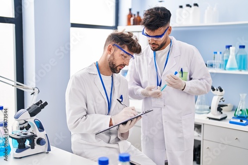 Young couple wearing scientist uniform working at laboratory